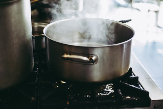 Water in a stainless casserole evaporates in the form of steam